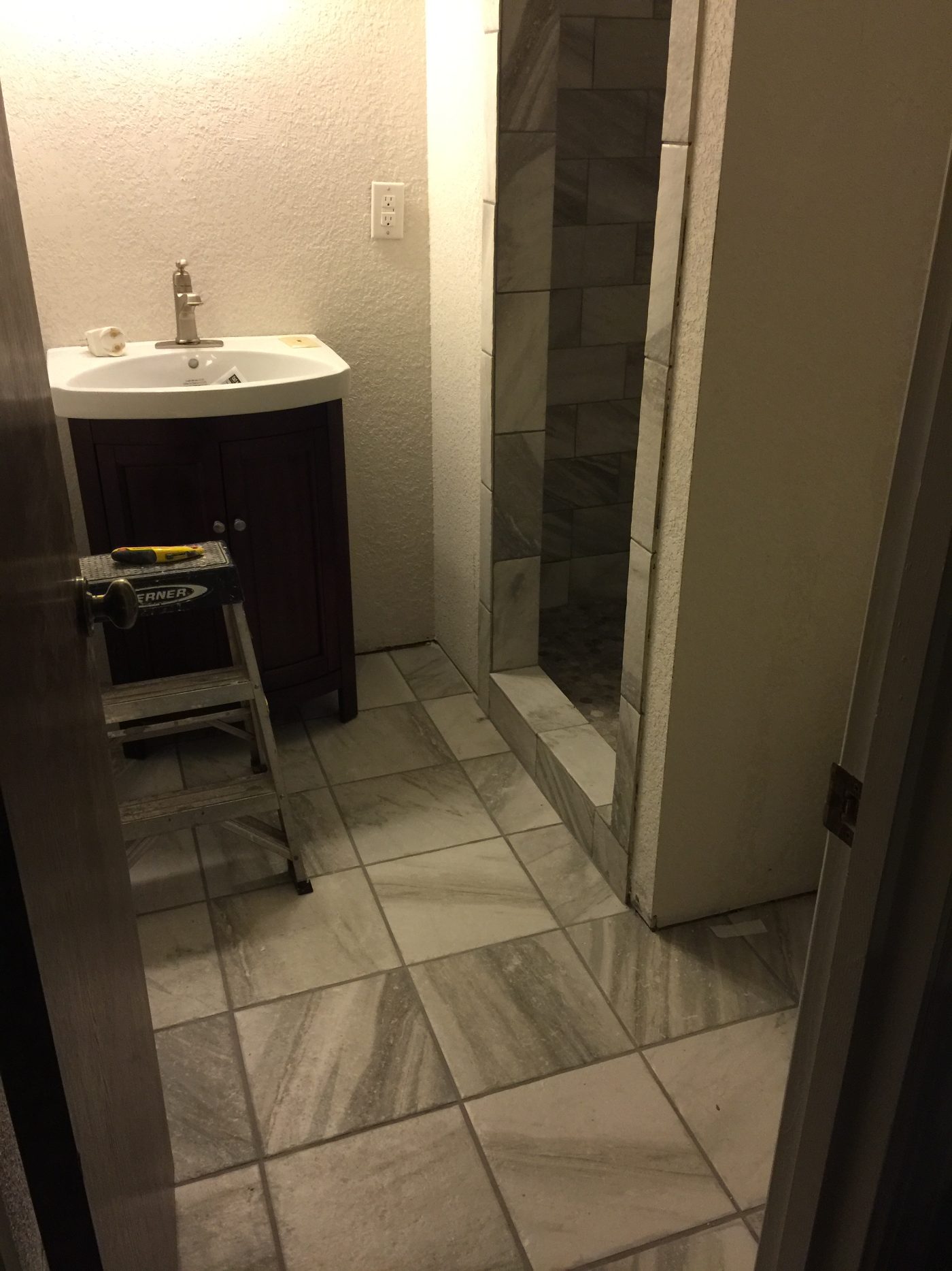 Finished bathroom remodel with new marble-look tile, custom shower, and vanity