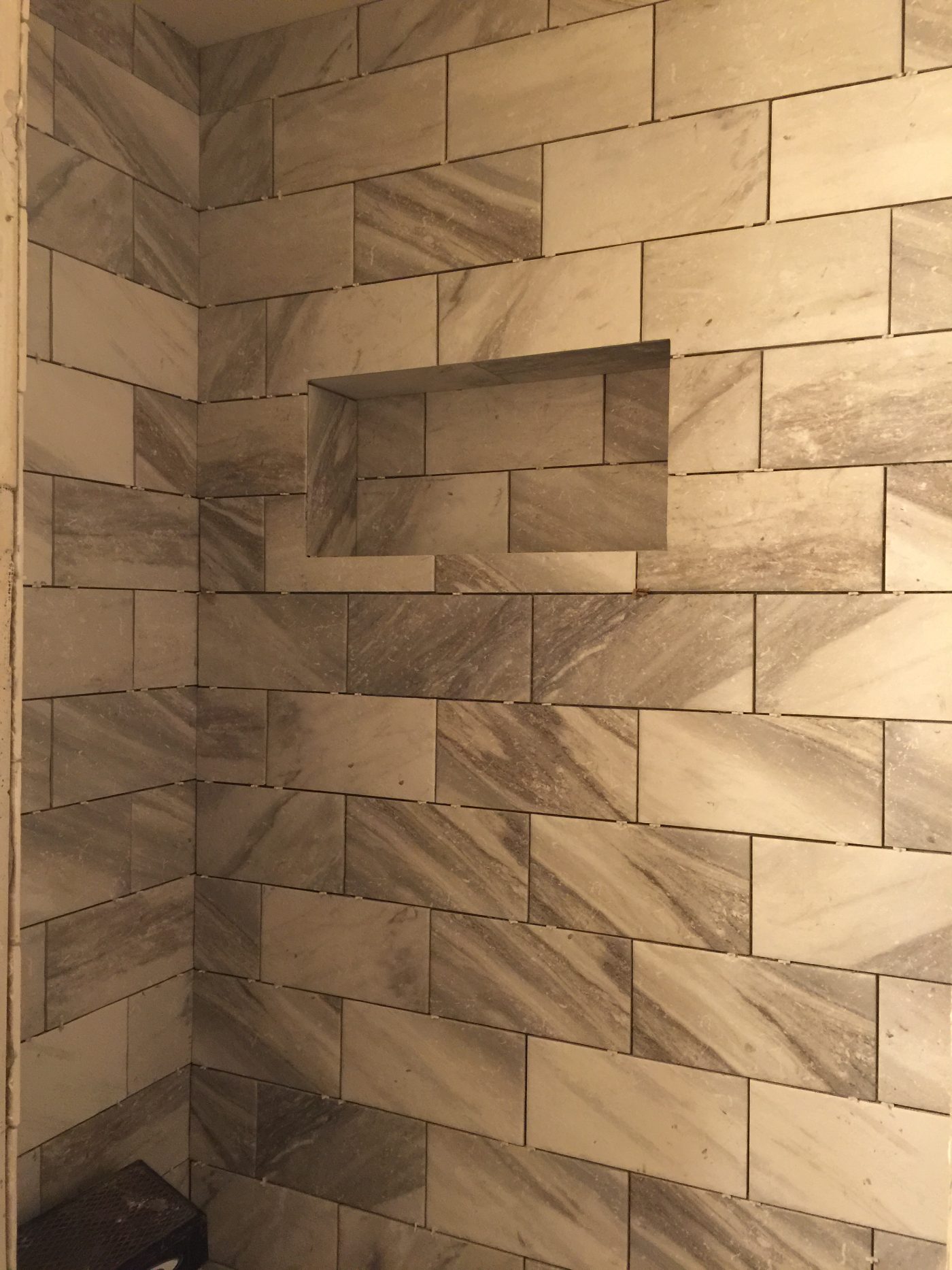 Custom tiled shower with a built-in niche from a Big Dawgz bathroom remodel