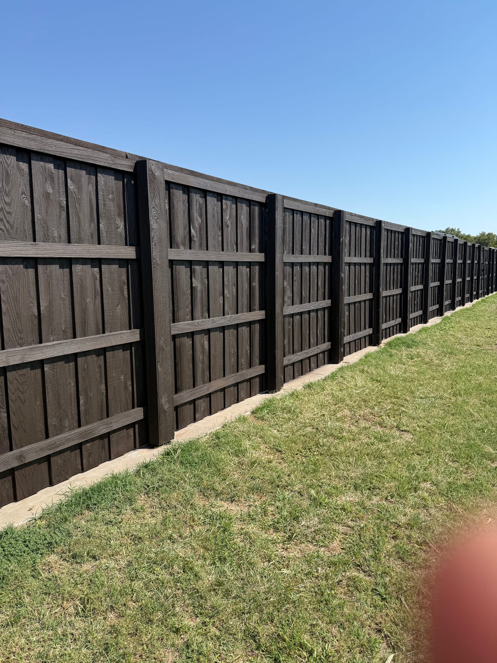 New stained wood privacy fence installation